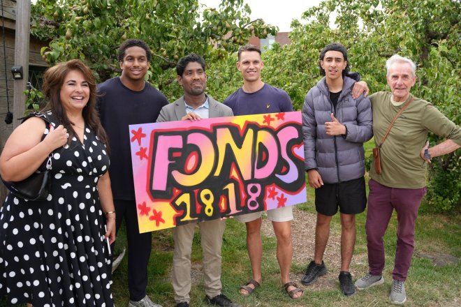 Projectadvsieur Avi Rewat neemt een grafitti-plaat in ontvangst van Stichting iDb
