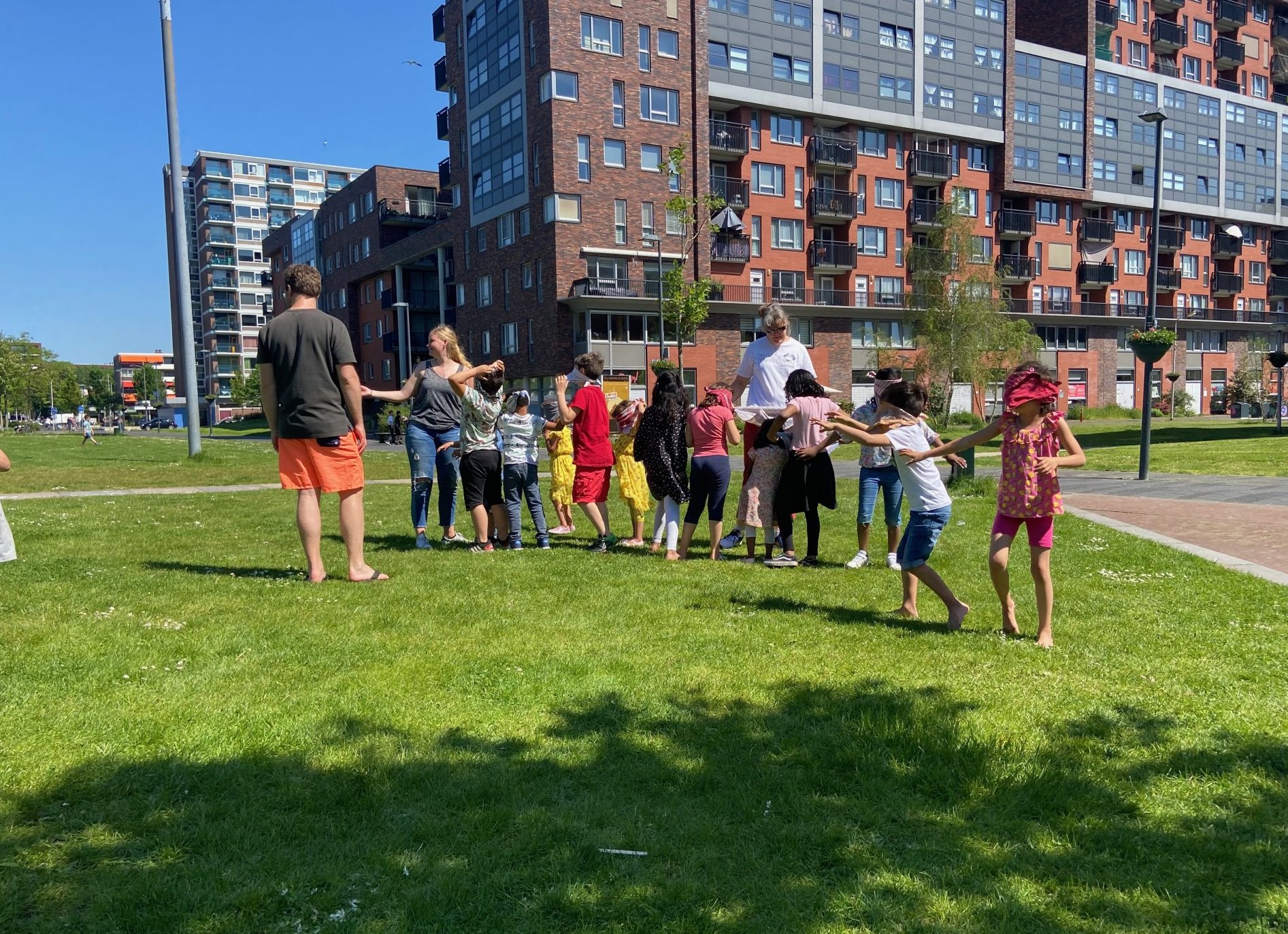 Buurtkinderen uit Voorhof en Buitenhof in Delft spelen op het gras, onderdeel van Kidsmall